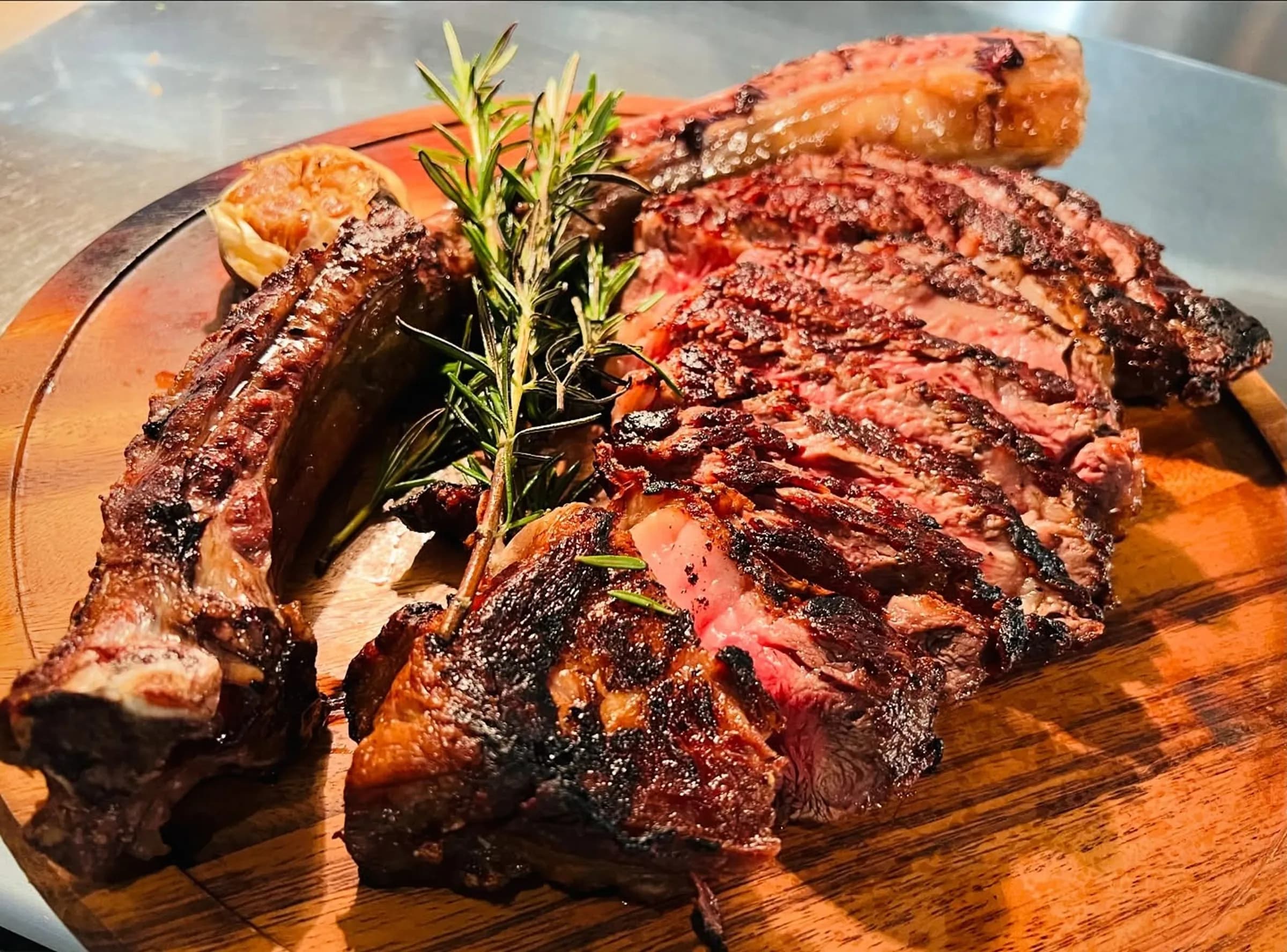 Sliced dry-aged Tomahawk steak on a wooden board
